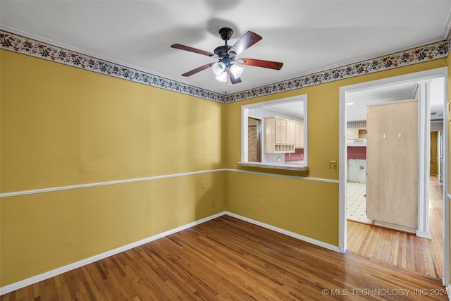 empty room with hardwood / wood-style floors and ceiling fan