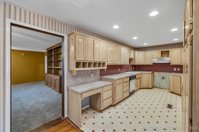 kitchen featuring light brown cabinets, sink, white dishwasher, and light colored carpet