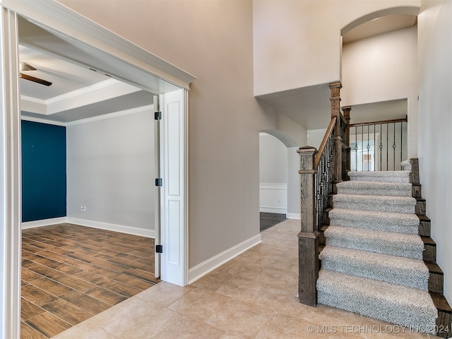 stairs featuring ceiling fan, tile patterned floors, and ornamental molding