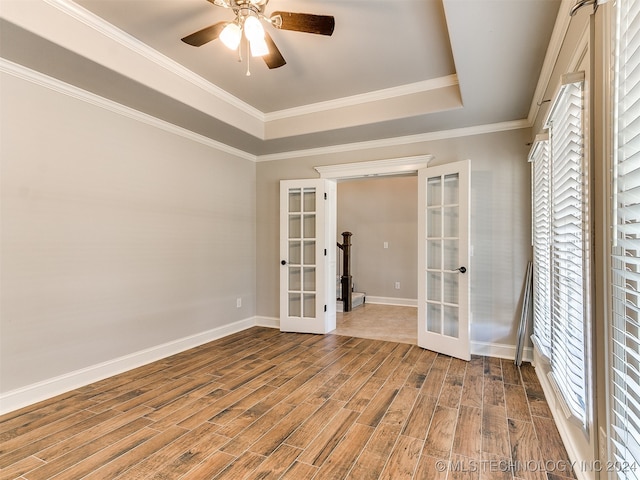 spare room with ornamental molding, french doors, a tray ceiling, ceiling fan, and hardwood / wood-style flooring