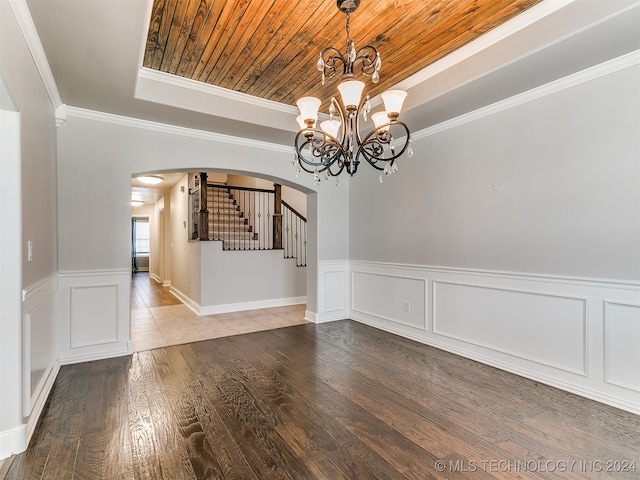 spare room with an inviting chandelier, wooden ceiling, hardwood / wood-style floors, and ornamental molding