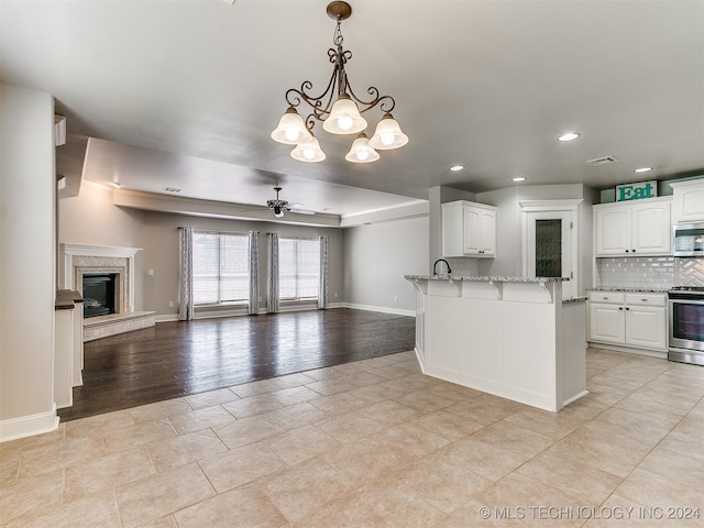 kitchen featuring stainless steel appliances, white cabinets, and light wood-type flooring