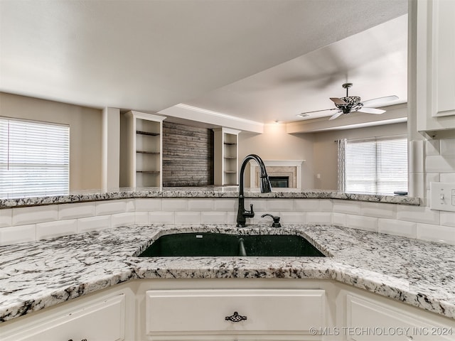 kitchen featuring ceiling fan, sink, tasteful backsplash, and white cabinets