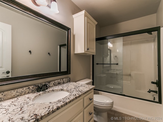 full bathroom with tile patterned flooring, toilet, shower / bath combination with glass door, and vanity