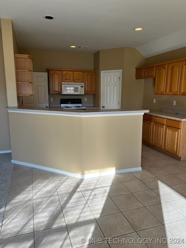 kitchen featuring light tile patterned floors and range with electric cooktop