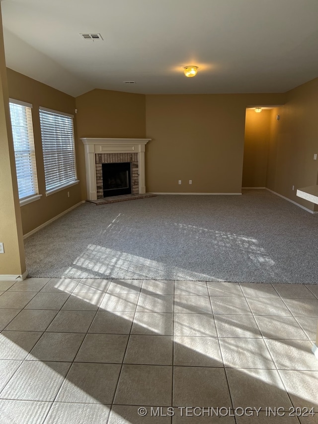 unfurnished living room featuring light tile patterned flooring and a fireplace