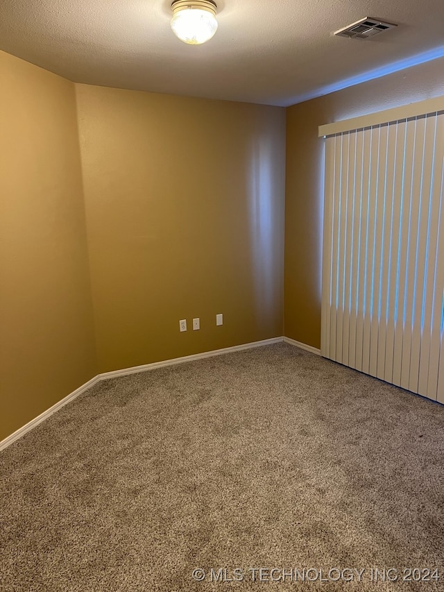 carpeted spare room featuring a textured ceiling