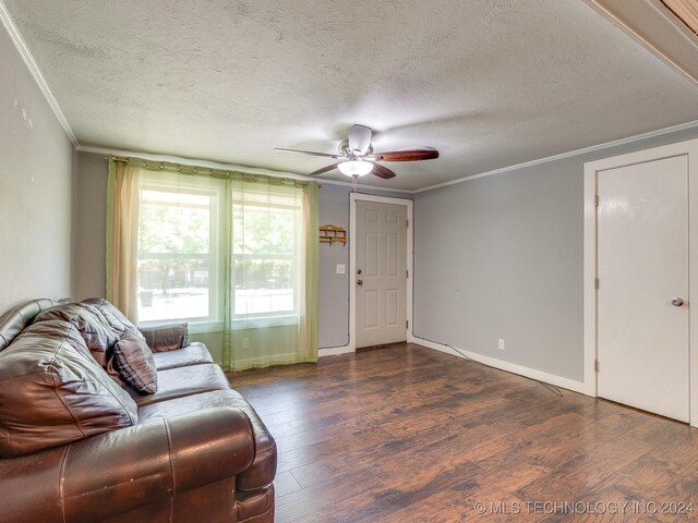 living room with ceiling fan, wood-type flooring, ornamental molding, and a textured ceiling