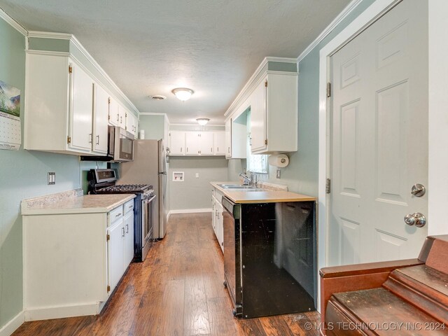 kitchen featuring sink, white cabinets, dark hardwood / wood-style flooring, stainless steel appliances, and crown molding