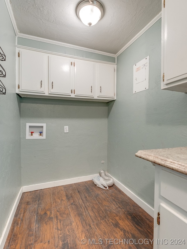 laundry room with cabinets, hookup for a washing machine, wood-type flooring, a textured ceiling, and crown molding