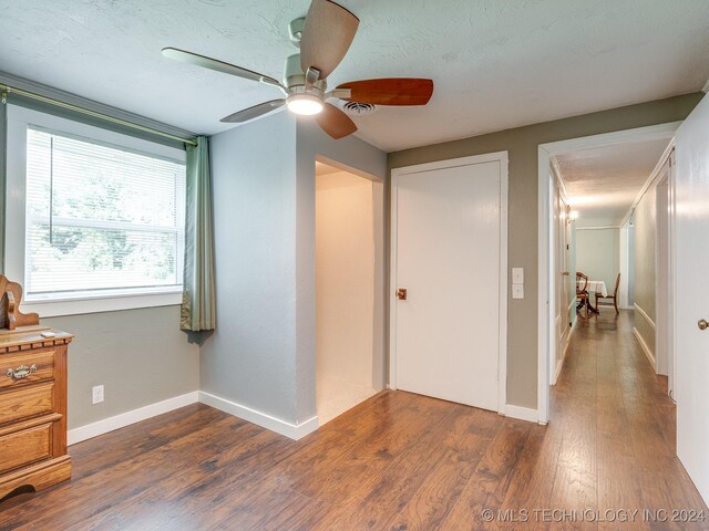 empty room with ceiling fan, dark hardwood / wood-style floors, and a textured ceiling