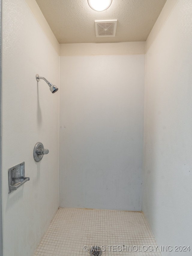 bathroom with tile patterned flooring and a textured ceiling