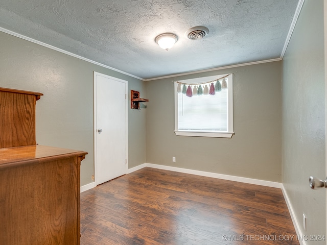 unfurnished room featuring a textured ceiling, ornamental molding, and wood-type flooring