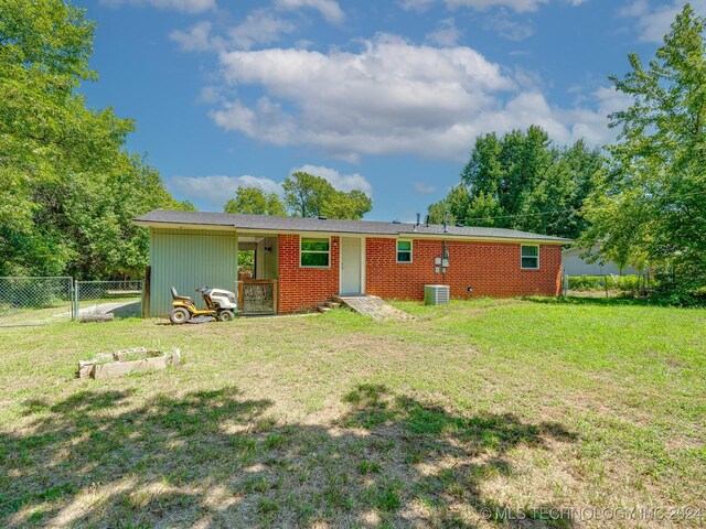 back of property with a yard and central air condition unit