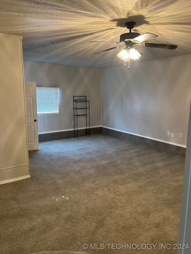 empty room with ceiling fan, a textured ceiling, and carpet flooring