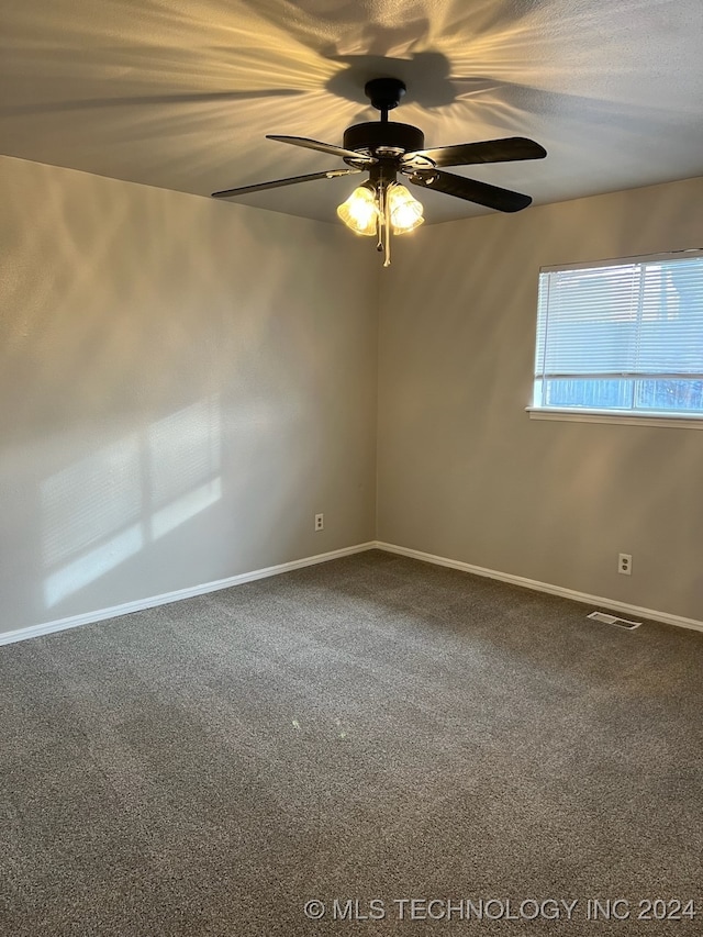 carpeted spare room featuring ceiling fan