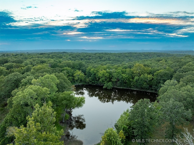 aerial view at dusk featuring a water view