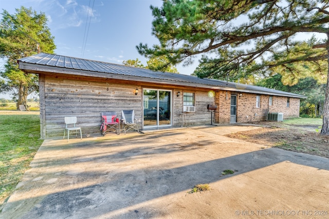 rear view of property featuring central AC, a patio area, and cooling unit