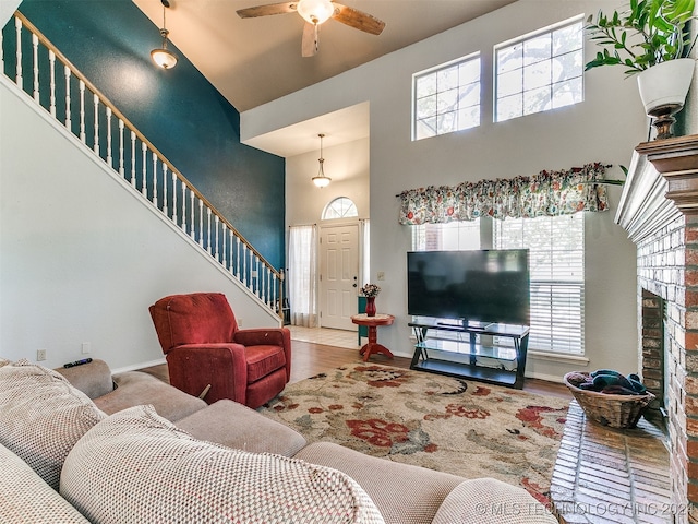 living room featuring hardwood / wood-style flooring, a towering ceiling, and ceiling fan