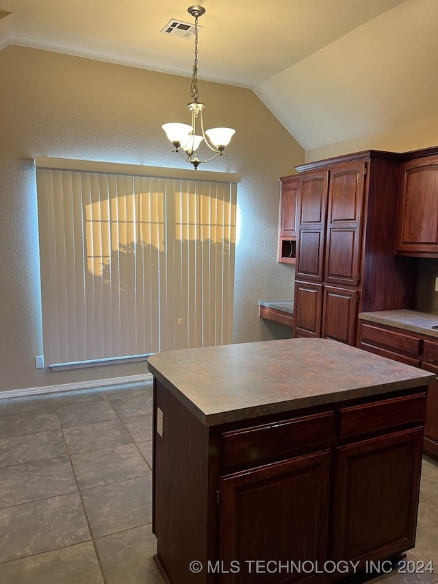 kitchen with decorative light fixtures, lofted ceiling, a center island, and tile patterned floors