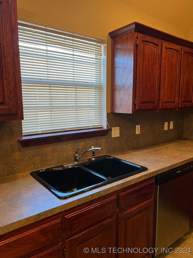 kitchen featuring sink, decorative backsplash, and stainless steel dishwasher