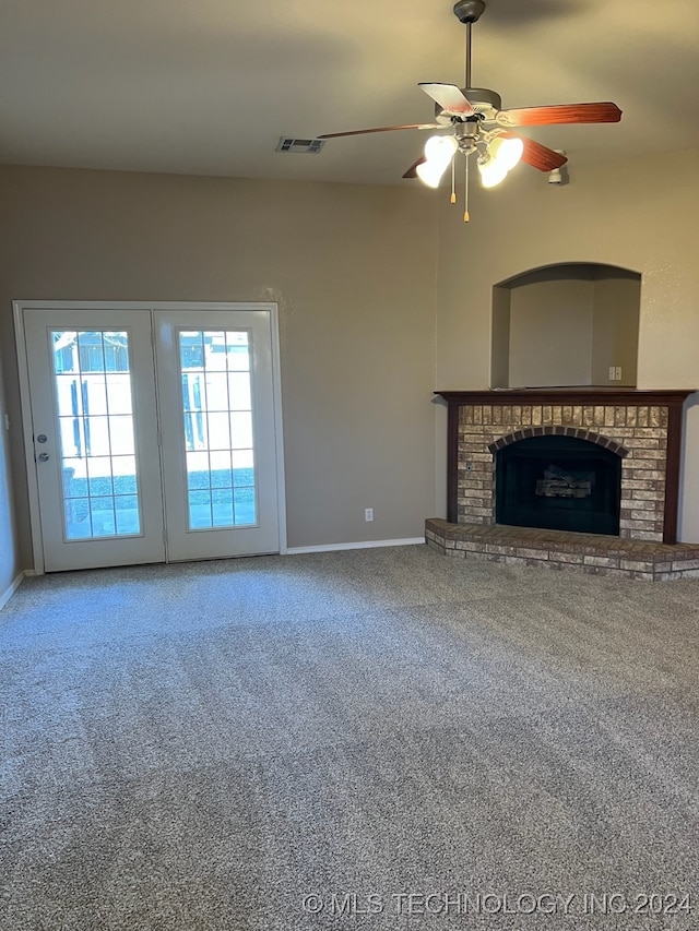 unfurnished living room with ceiling fan, carpet, french doors, and a fireplace