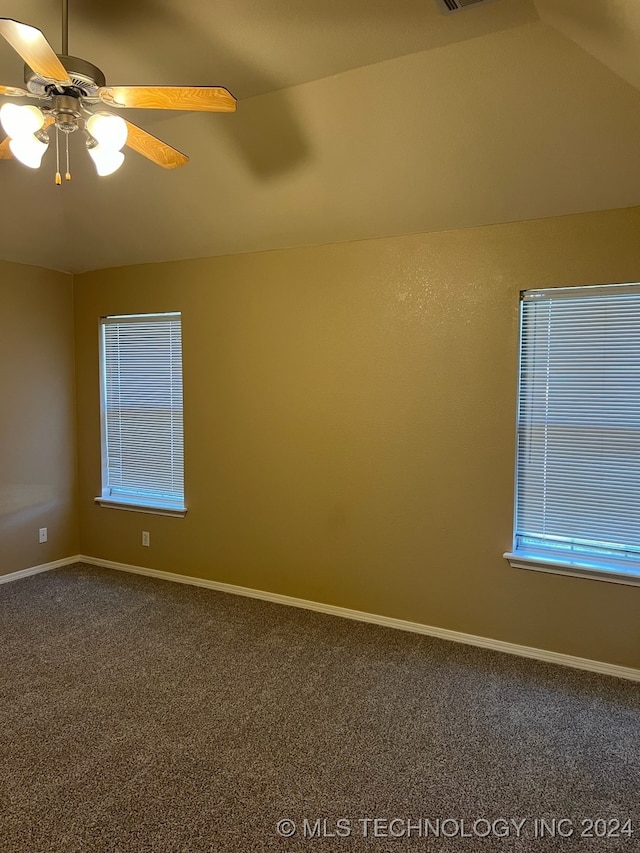 carpeted spare room with ceiling fan and vaulted ceiling