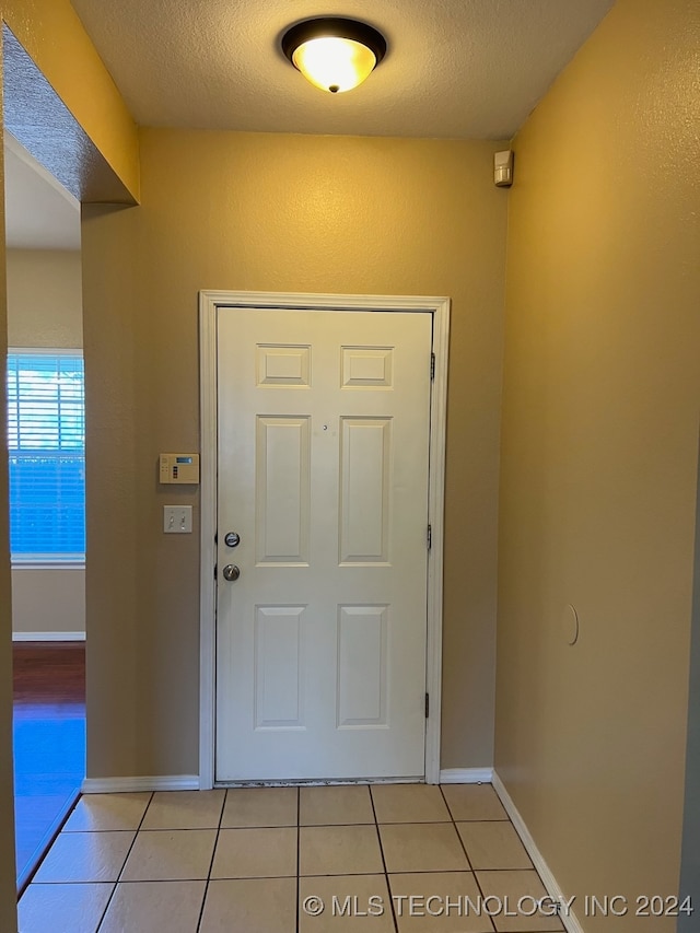 tiled foyer entrance with a textured ceiling