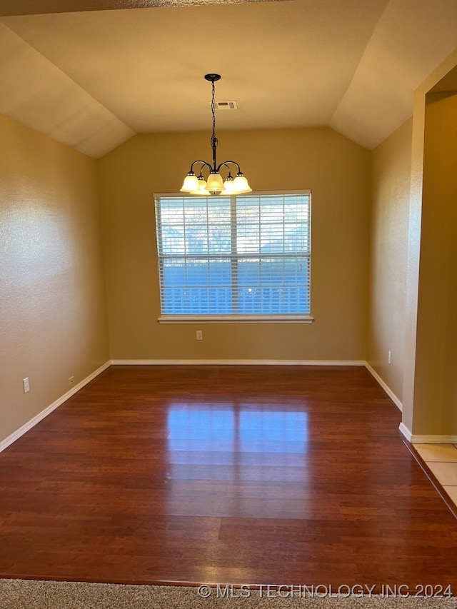 unfurnished room featuring hardwood / wood-style floors, vaulted ceiling, and an inviting chandelier