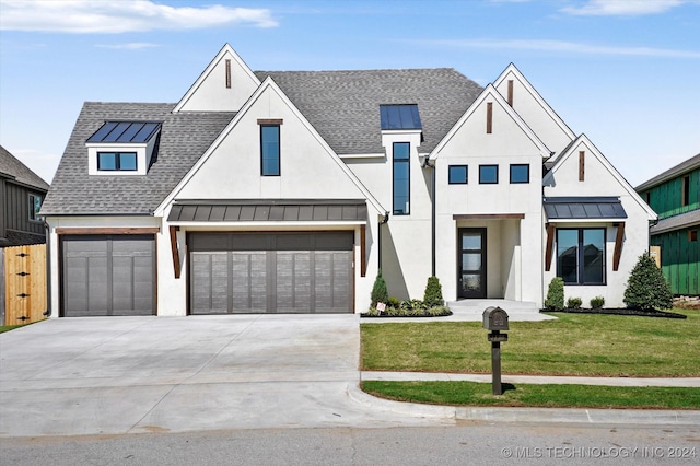 modern farmhouse style home featuring a front yard and a garage