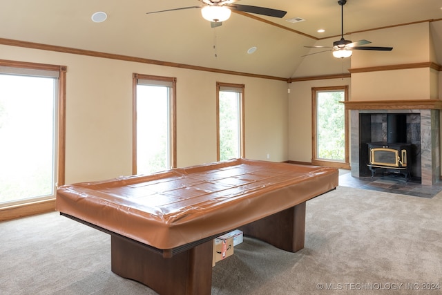 game room featuring carpet flooring, a wood stove, ceiling fan, and vaulted ceiling