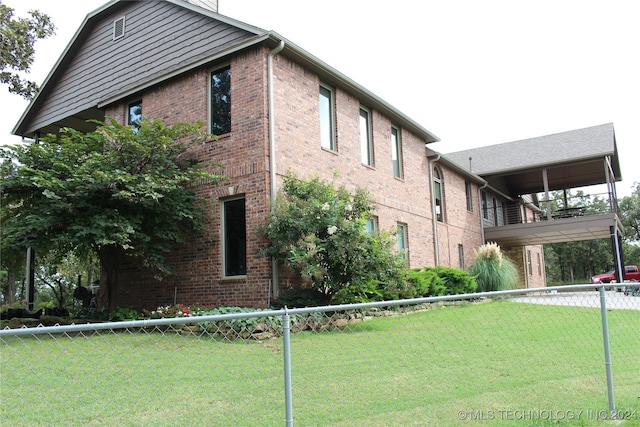 view of side of home with a lawn and a balcony