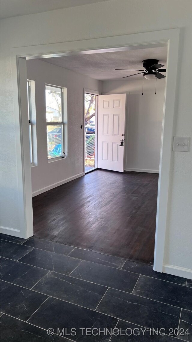 foyer featuring dark wood finished floors, baseboards, and ceiling fan