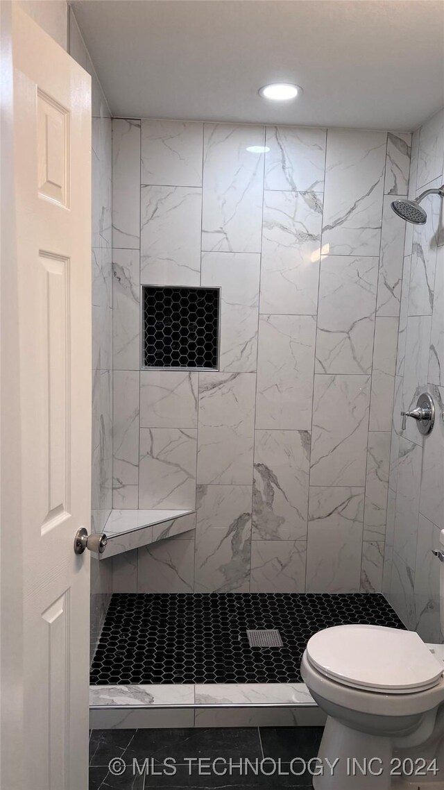 bathroom featuring recessed lighting, a tile shower, and toilet