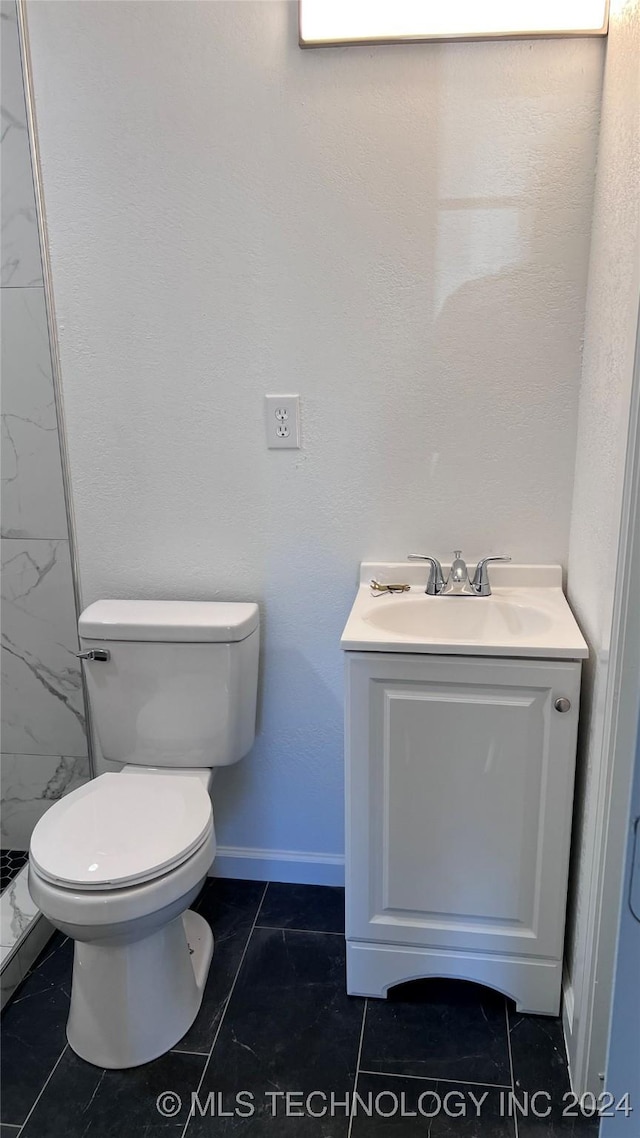 full bath with baseboards, vanity, toilet, and walk in shower