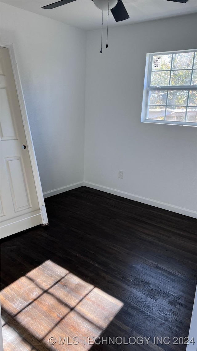 spare room with dark wood-style floors, ceiling fan, and baseboards