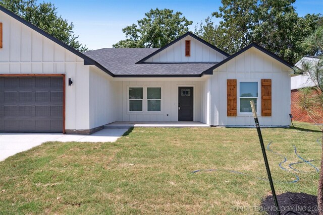 modern farmhouse style home with a front lawn and a garage