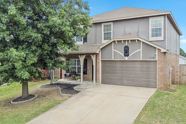 view of front of property featuring a garage, a front lawn, and a porch