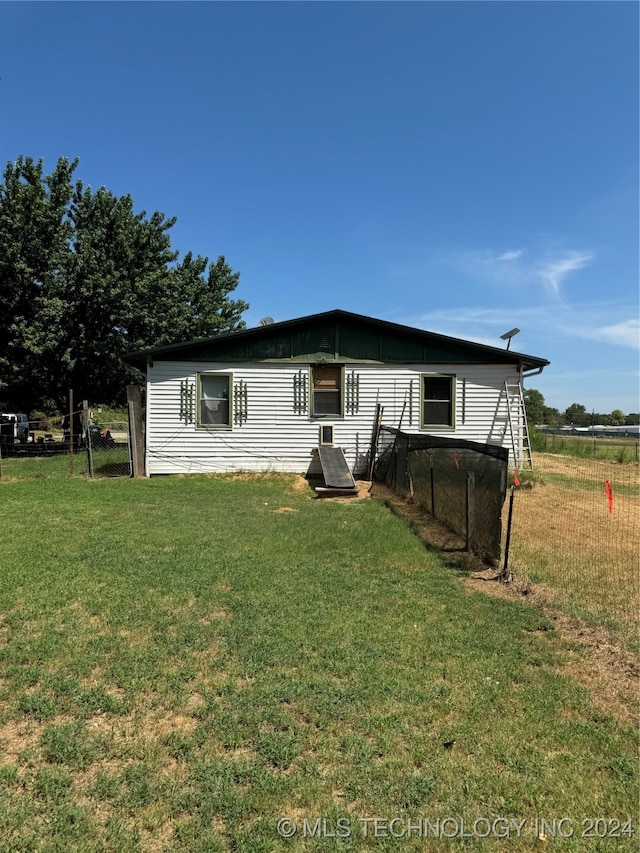 rear view of property with a lawn