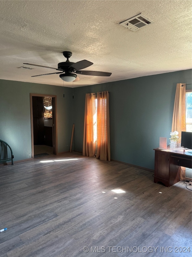 empty room with wood-type flooring, ceiling fan, and a textured ceiling