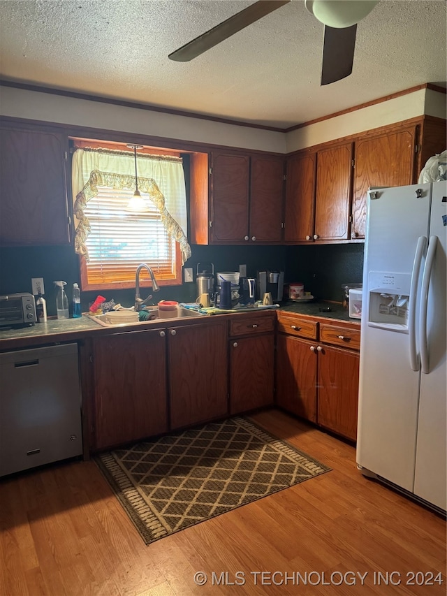 kitchen with light wood-type flooring, white refrigerator with ice dispenser, sink, ceiling fan, and stainless steel dishwasher