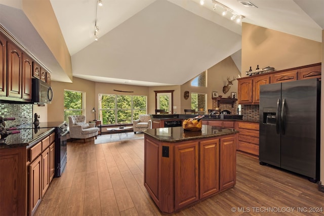 kitchen featuring tasteful backsplash, a center island, hardwood / wood-style floors, and black appliances