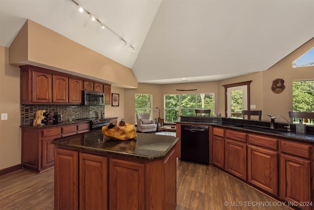 kitchen featuring tasteful backsplash, lofted ceiling, sink, a center island, and stainless steel appliances