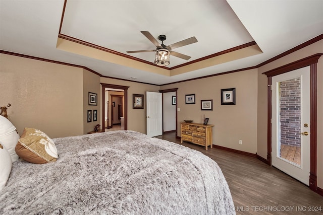 bedroom with dark hardwood / wood-style flooring, access to exterior, a tray ceiling, and ceiling fan