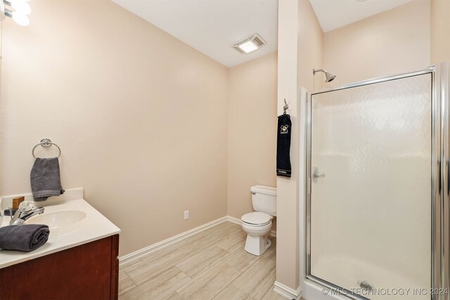 bathroom featuring vanity, toilet, and walk in shower