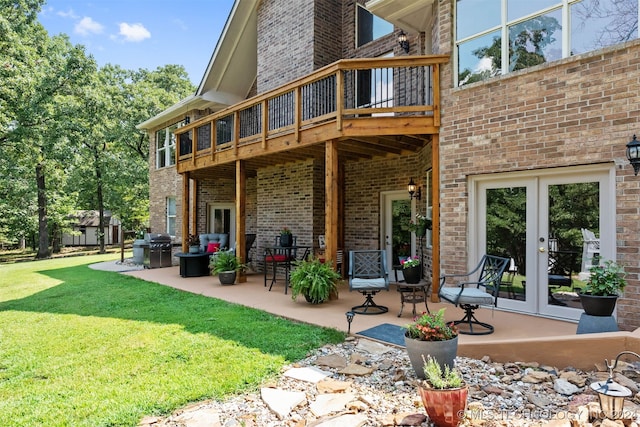 back of house featuring a patio, a lawn, and french doors