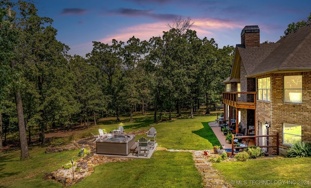 yard at dusk featuring a patio and an outdoor fire pit