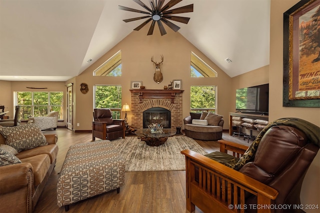 living room with hardwood / wood-style flooring, high vaulted ceiling, and a fireplace