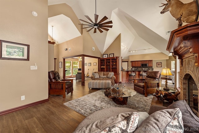 living room with dark hardwood / wood-style flooring, high vaulted ceiling, ceiling fan, and a fireplace