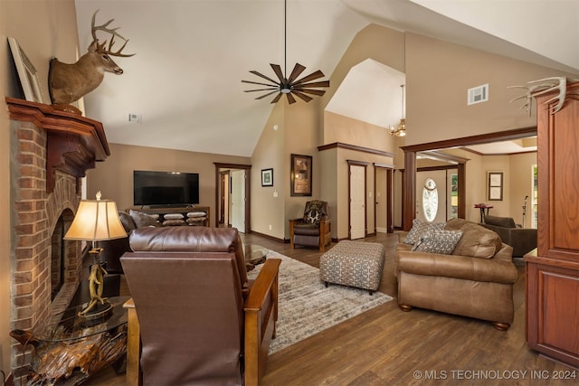 living room with ceiling fan, dark hardwood / wood-style flooring, high vaulted ceiling, and a brick fireplace